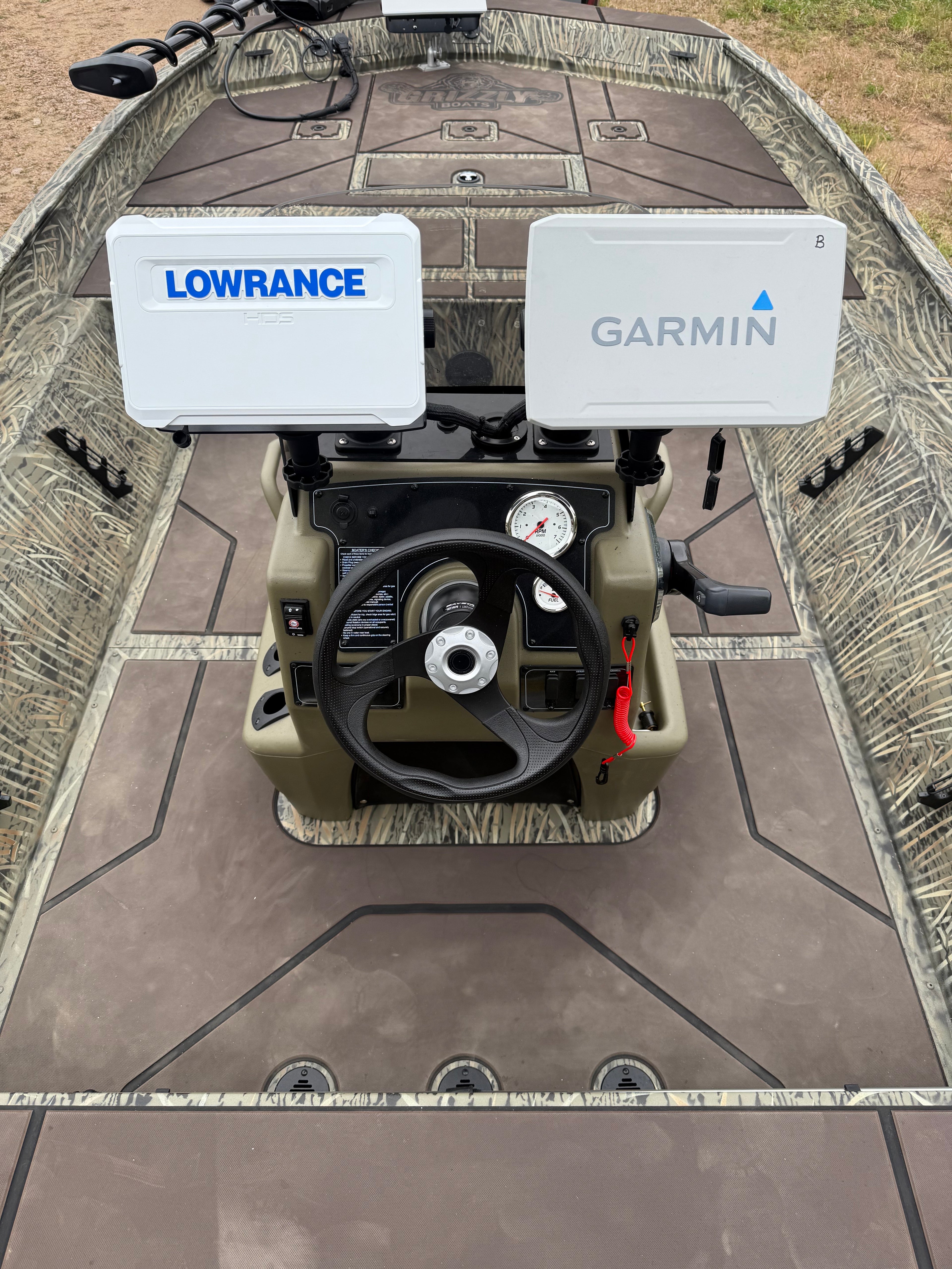 A photo of a camouflage boat with Lowrance contour finder and Garmin Fish finder 