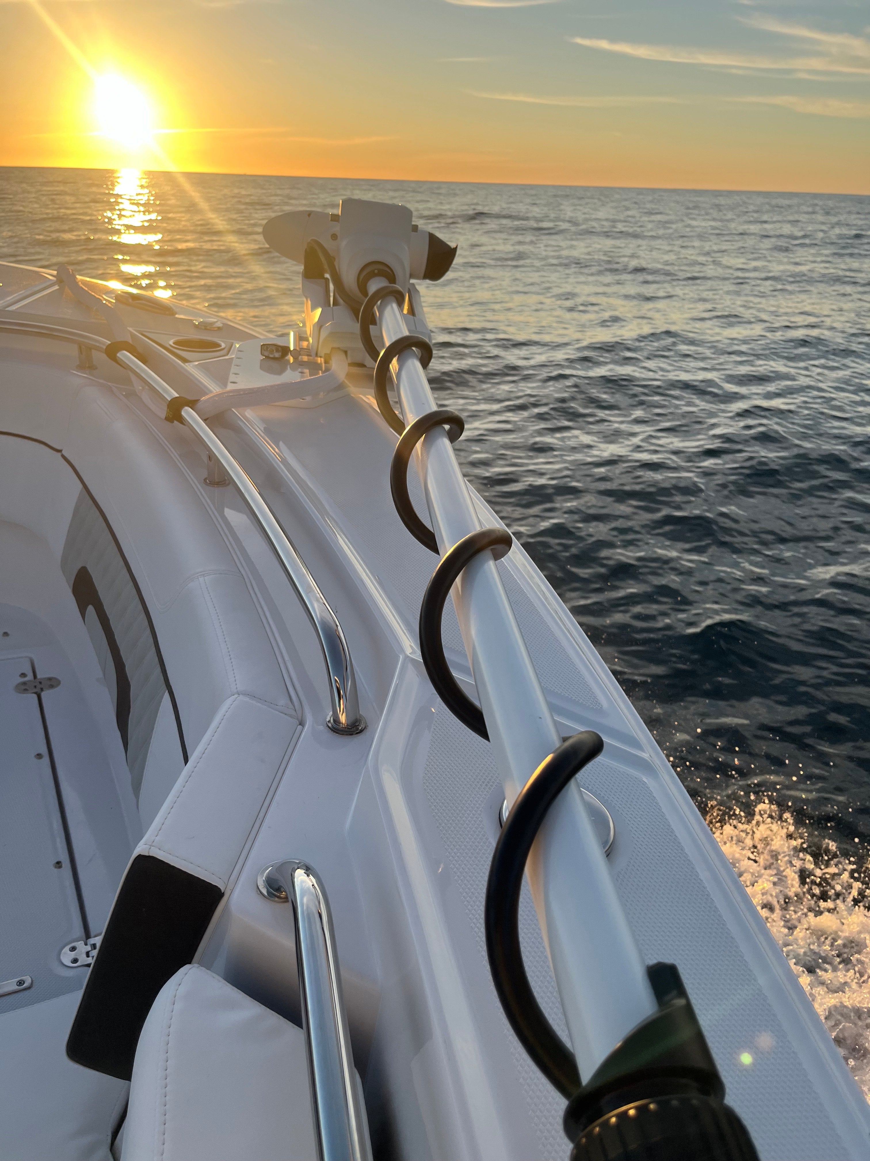 Photo of boat with trolling motor on the water at sunset